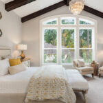 Bedroom with unique touches like mirrors, exposed beams and natural light