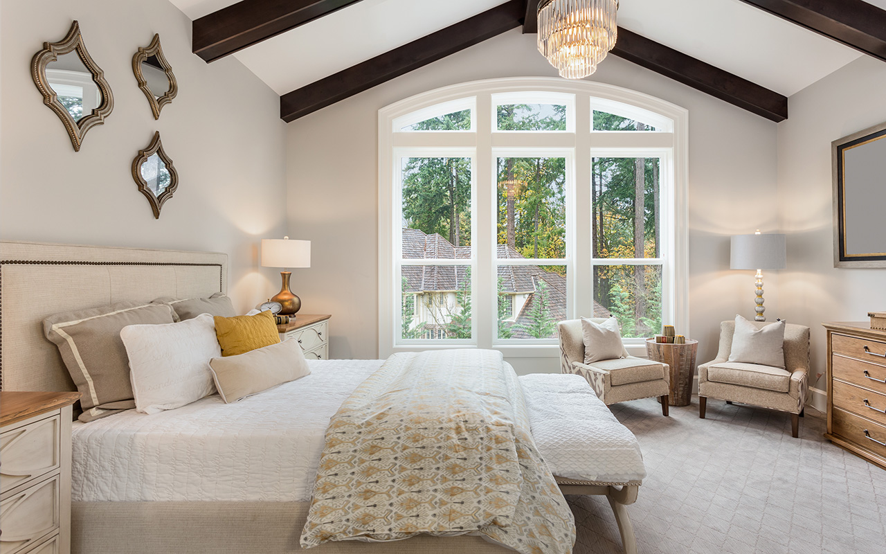 Bedroom with unique touches like mirrors, exposed beams and natural light