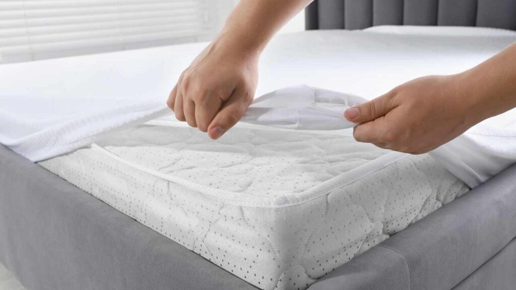 a person putting a mattress topper on top of a bed