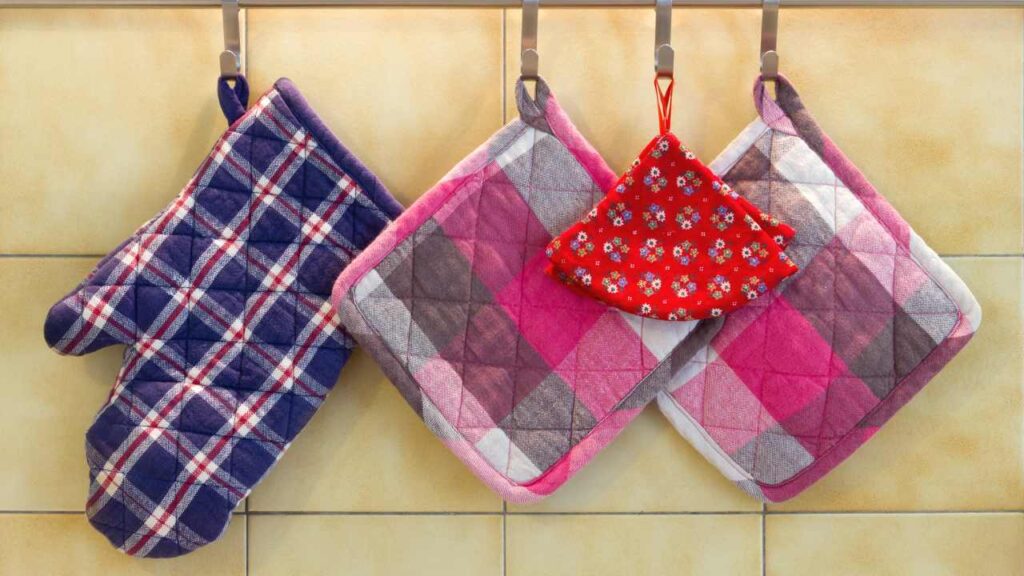 three potholders hanging on a wall in a kitchen