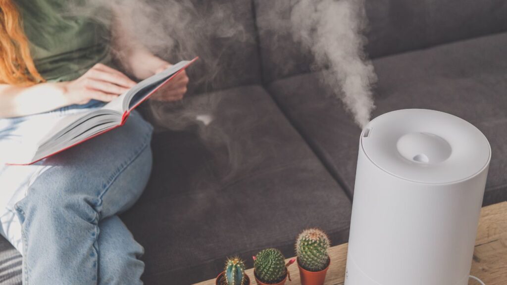 a person reading a book next to a humidifier