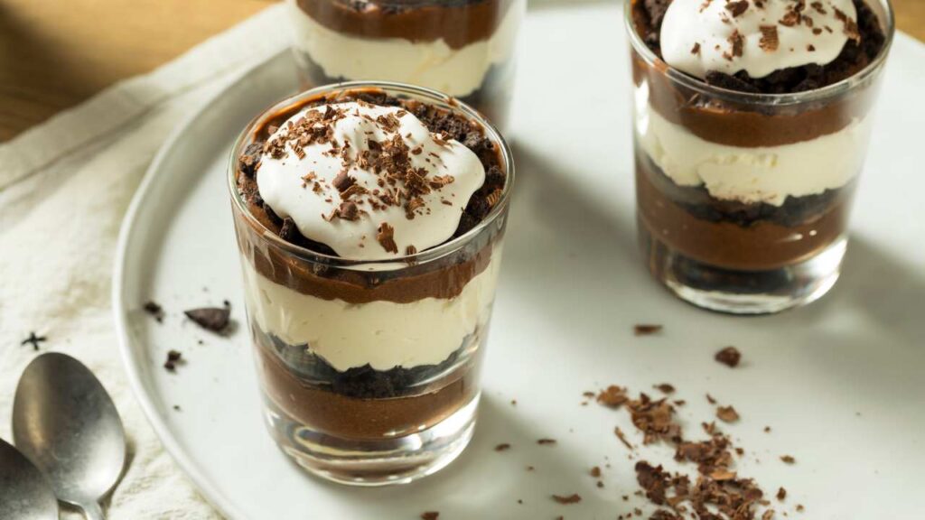 three dessert cups topped with chocolate and whipped cream