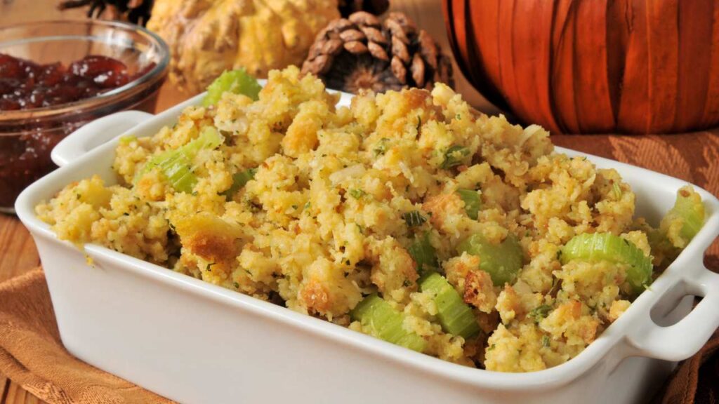 cornbread stuffing in a white casserole dish on a wooden table