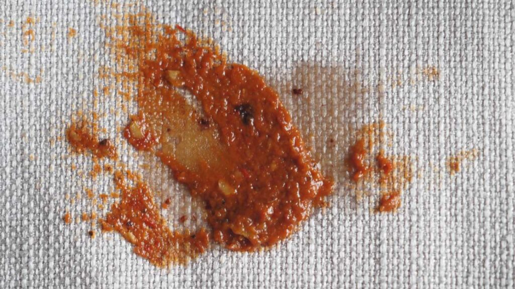 a close up of an orange sauce on a piece of cloth