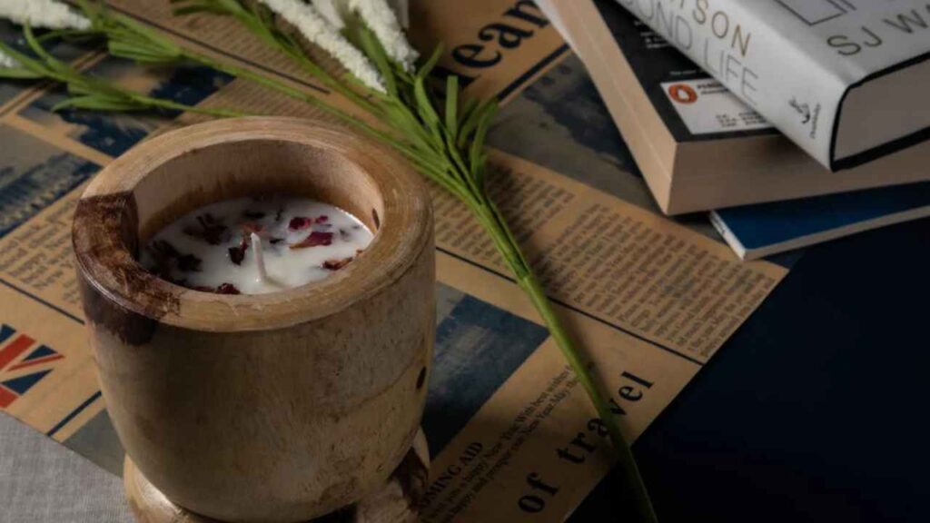 a candle sitting on top of some books and flowers