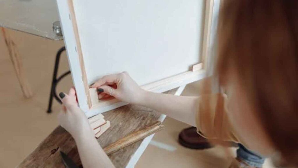 a person is painting on a piece of wood