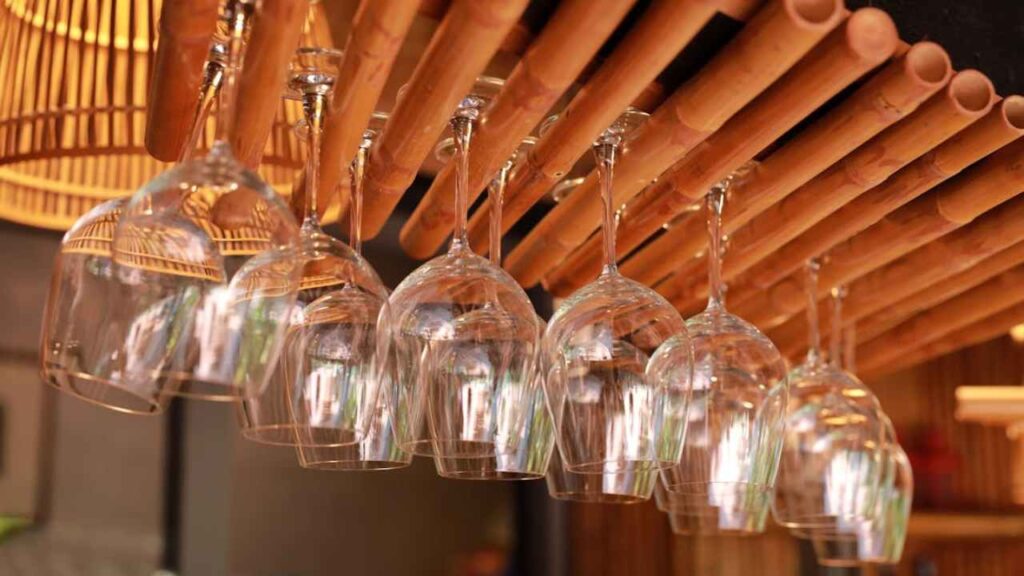 wine glasses hanging from bamboo sticks in a restaurant