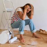 a person sitting on the floor in a room covered in paint