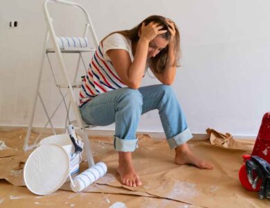 a person sitting on the floor in a room covered in paint