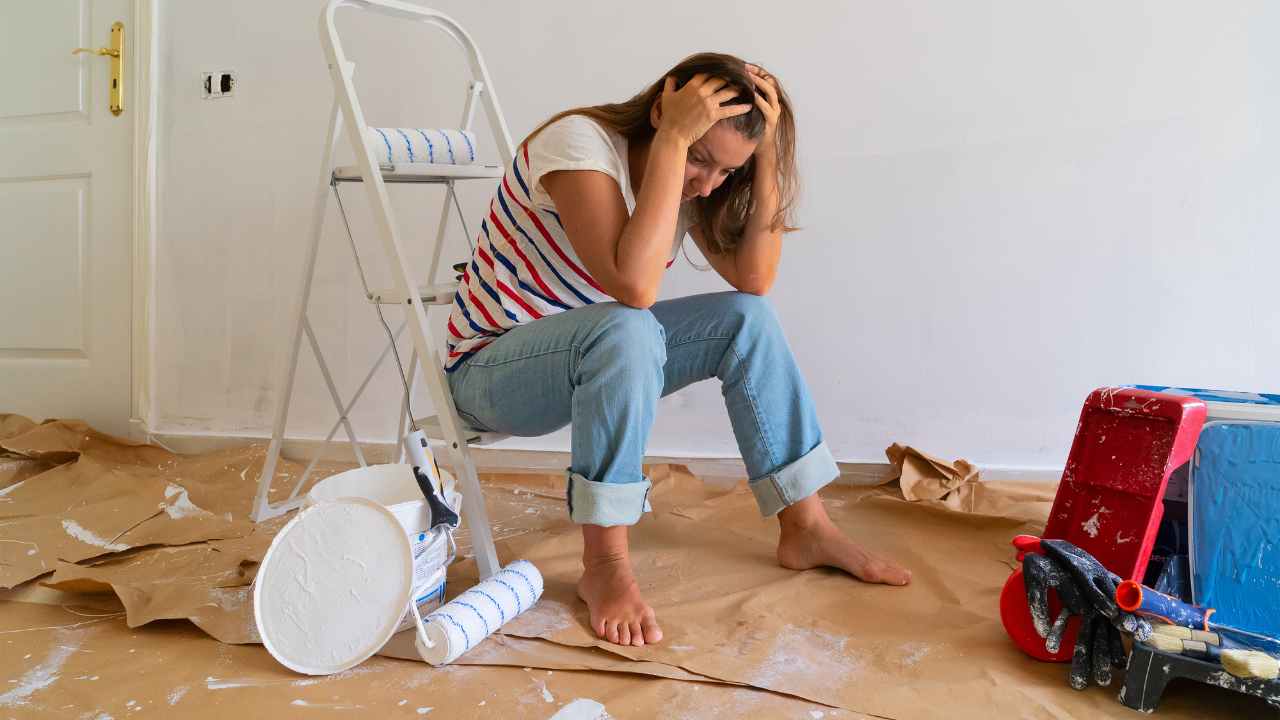 a person sitting on the floor in a room covered in paint