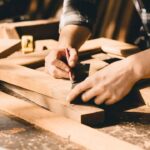 a person is working on some wooden furniture