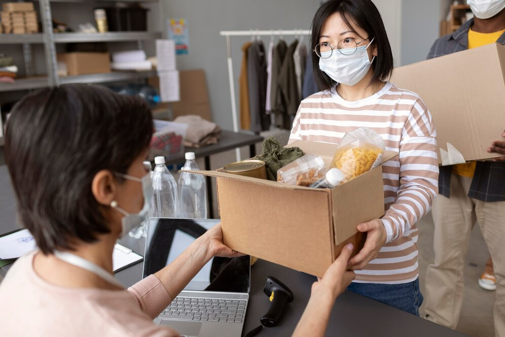 Woman giving donations in a cardboard box