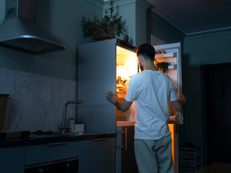 man looking in the fridge at night