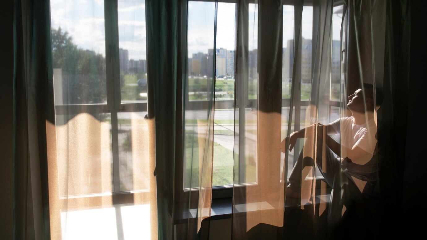 man sitting beside a window