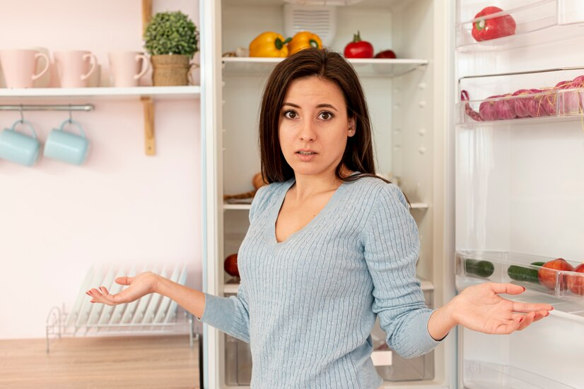 Confused woman in front of fridge