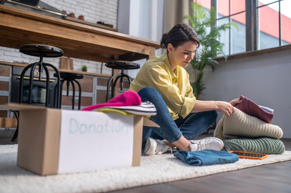 Woman packing a cardboard box labeled "Donation"