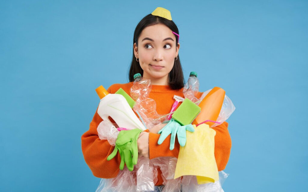 woman holding many cleaning supplies