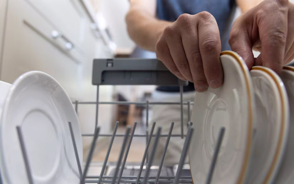 Man loading a dish washer