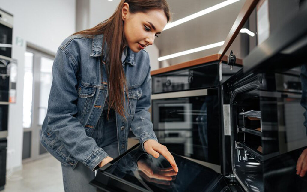 Woman opening oven door