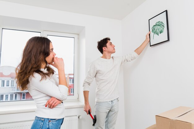 Couple hanging up an art piece